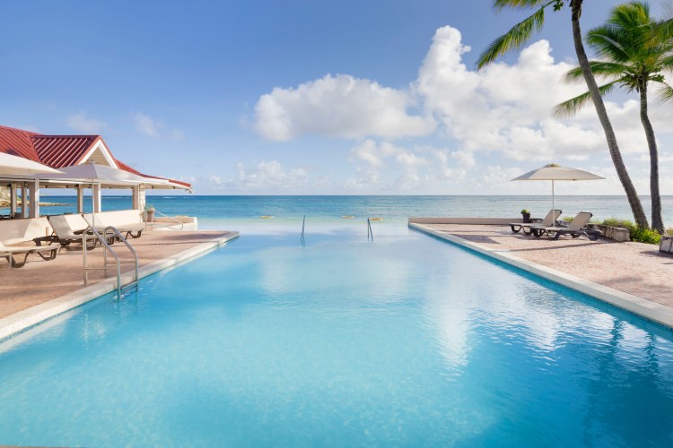 Infinity Pool beachfront at caribbean resort. 